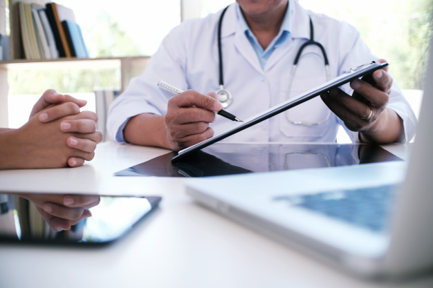 professional-medical-doctor-in-white-uniform-gown-coat-interview-consulting-patient_1715-1418